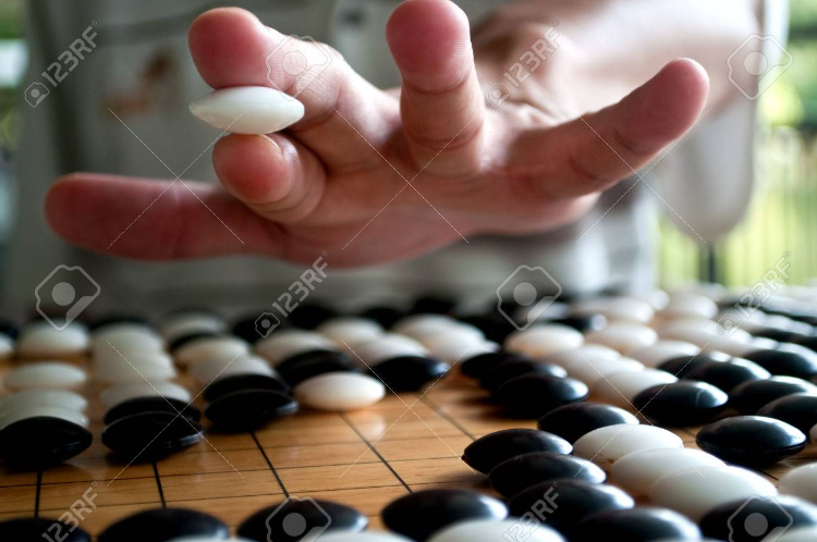 48802392-white-go-player-closeup-hand-showing-how-to-hold-the-piece-selected-focus-1.png